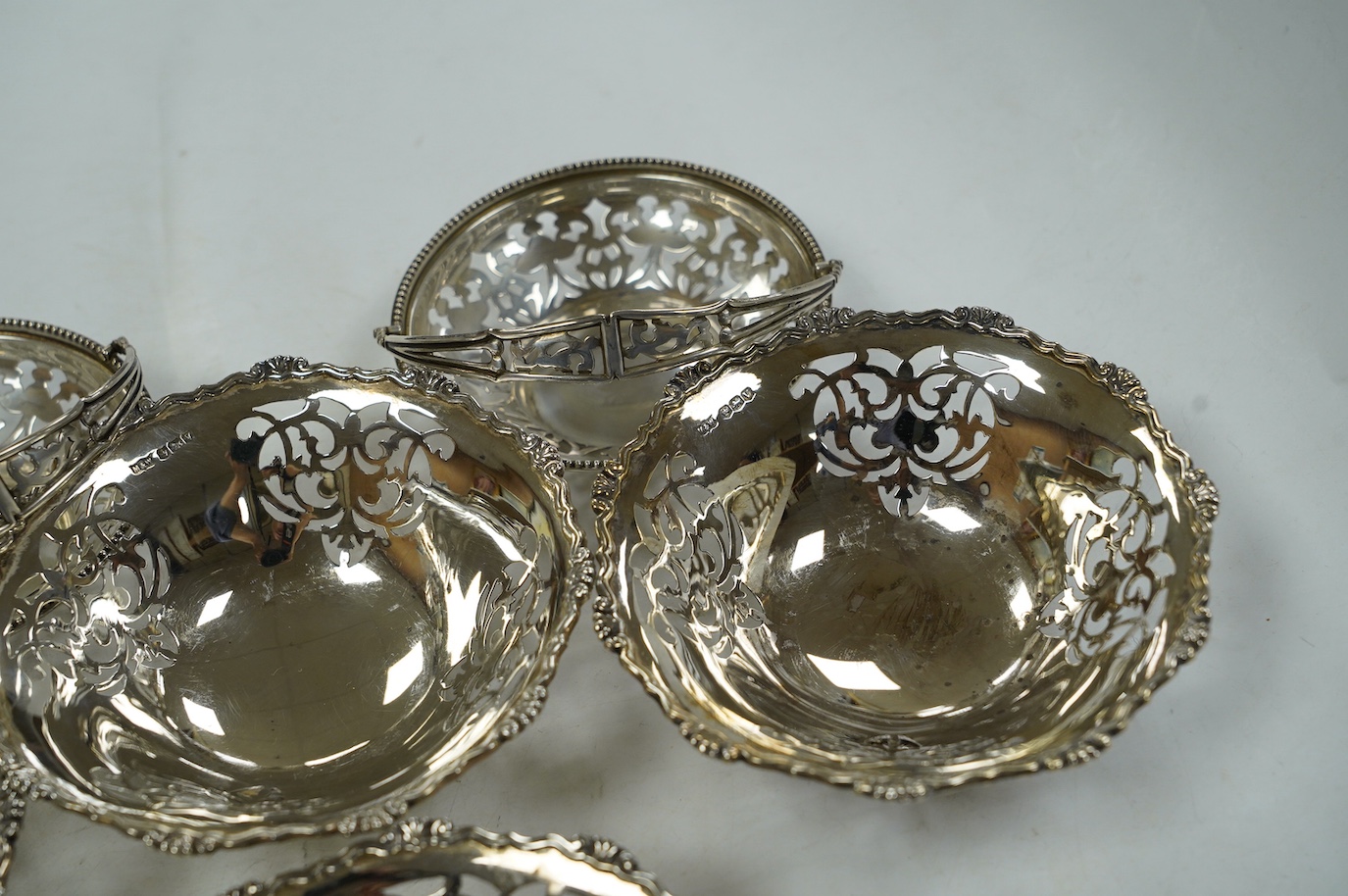 A set of four George VI pierced silver bonbon dishes, by Mappin & Webb, Sheffield, 1938, diameter 12cm and an earlier pair of silver bonbon baskets, 15.7oz. Condition - fair